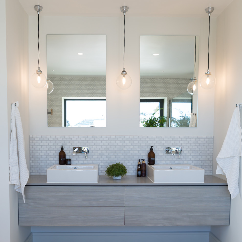 На фото: ванная комната в современном стиле с плоскими фасадами, светлыми деревянными фасадами, серой плиткой, плиткой мозаикой, белыми стенами, настольной раковиной, столешницей из дерева и серой столешницей с