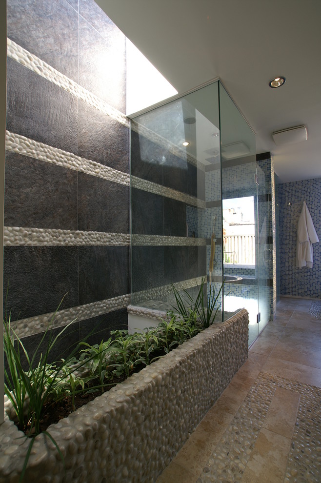 Réalisation d'une grande salle de bain principale bohème avec une douche à l'italienne, un carrelage marron, une plaque de galets, un mur multicolore et un sol en calcaire.