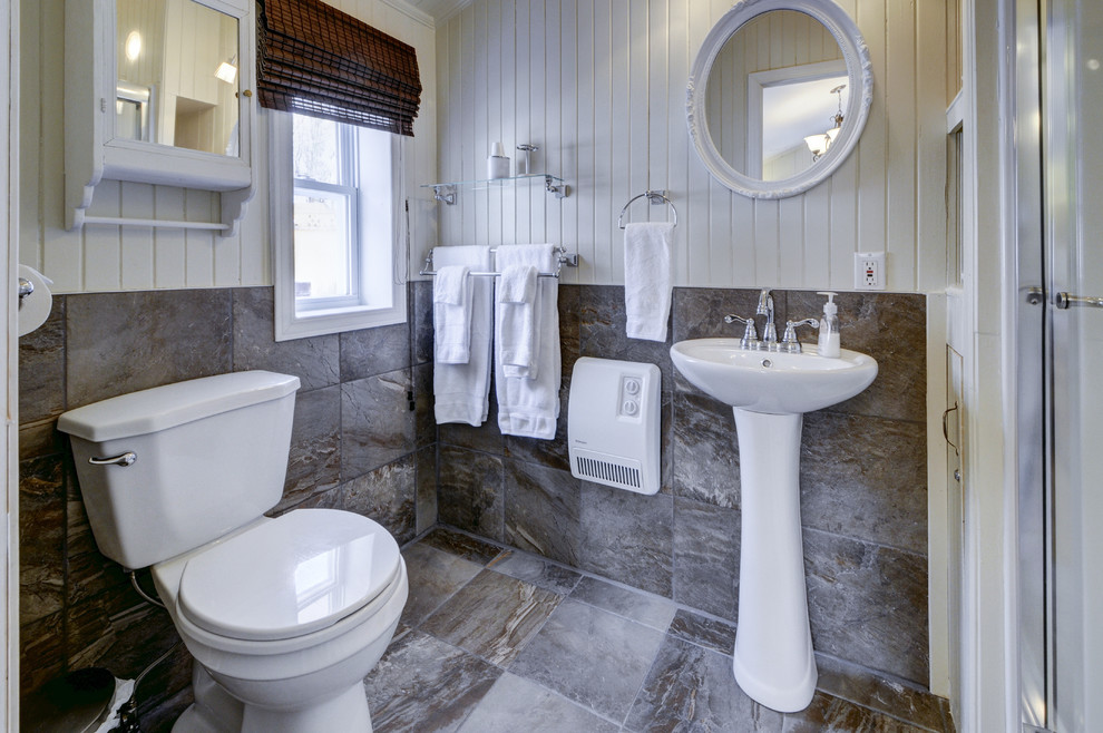 Immagine di una piccola stanza da bagno con doccia rustica con lavabo a colonna, doccia alcova, WC a due pezzi, piastrelle marroni, piastrelle in gres porcellanato, pareti beige e pavimento in gres porcellanato