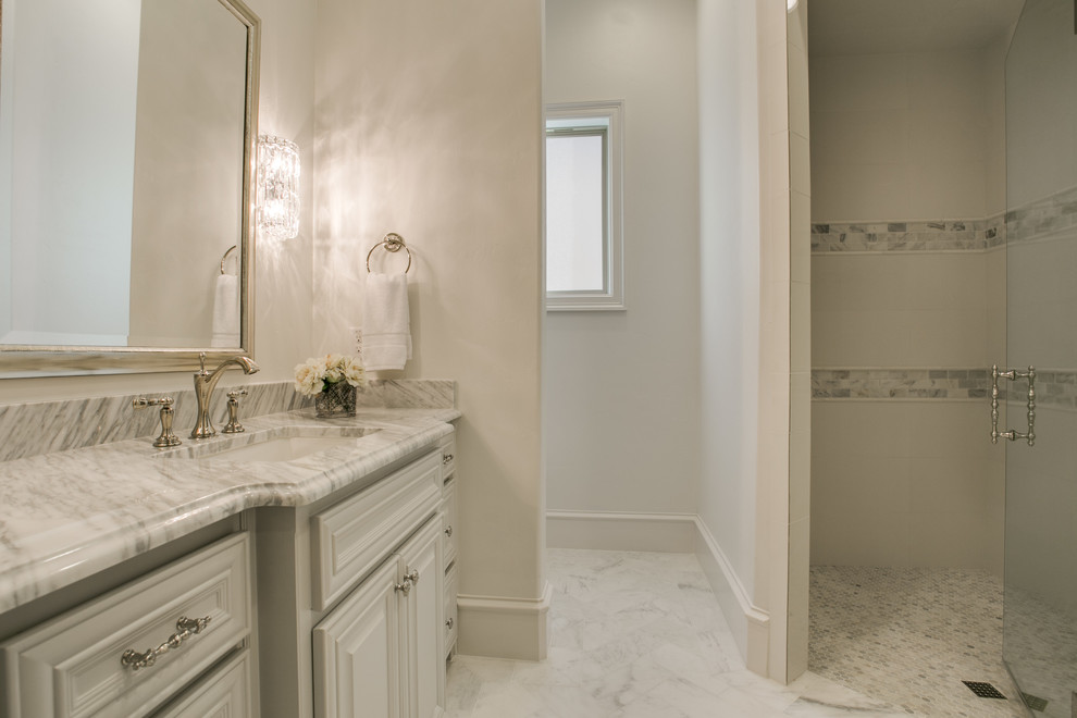 Small transitional kids' gray tile and stone tile marble floor corner shower photo in Dallas with raised-panel cabinets, white cabinets, a two-piece toilet, white walls, an undermount sink and marble countertops