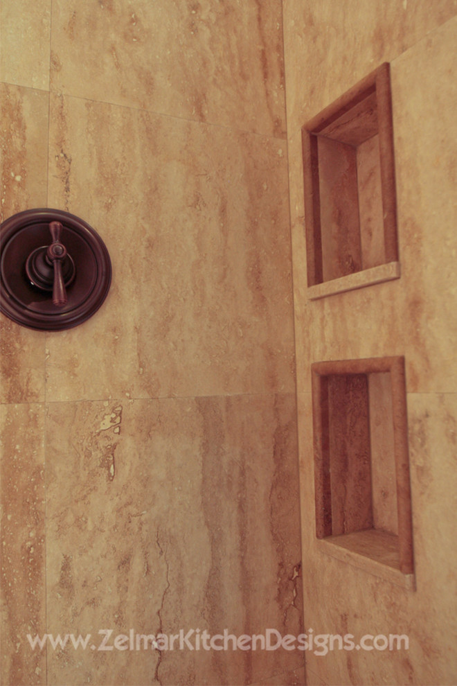 Cette image montre une salle de bain principale traditionnelle en bois foncé de taille moyenne avec un lavabo encastré, un placard avec porte à panneau surélevé, un plan de toilette en granite, un carrelage beige et un carrelage de pierre.