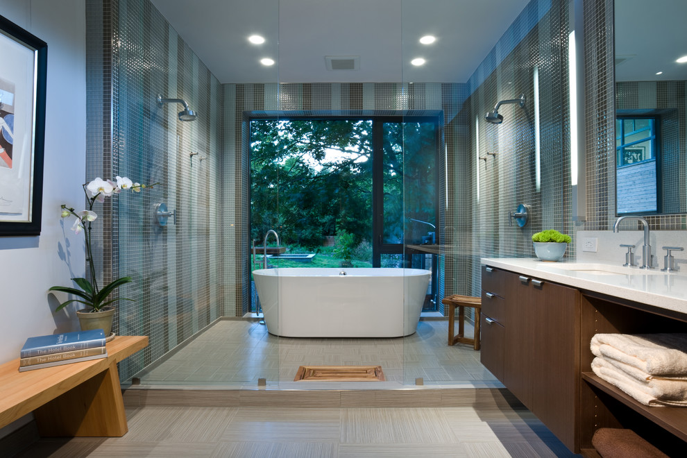 На фото: ванная комната в современном стиле с врезной раковиной, плоскими фасадами, темными деревянными фасадами, отдельно стоящей ванной, двойным душем, зеленой плиткой и плиткой мозаикой с