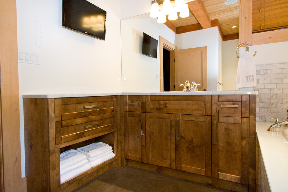 Inspiration pour une salle d'eau chalet en bois brun de taille moyenne avec un lavabo encastré, un placard à porte shaker, un plan de toilette en granite, une baignoire posée, un carrelage gris, un mur blanc et sol en béton ciré.