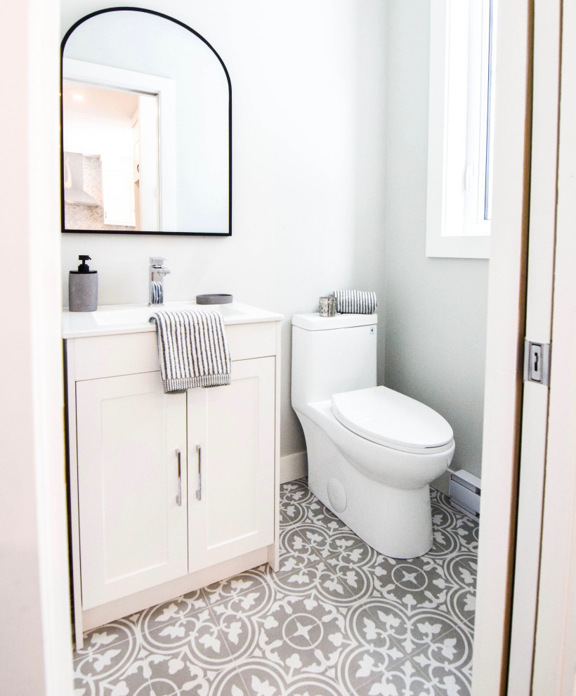 Kleines Country Duschbad mit Schrankfronten im Shaker-Stil, weißen Schränken, Toilette mit Aufsatzspülkasten, grauer Wandfarbe, Mosaik-Bodenfliesen, integriertem Waschbecken, Quarzwerkstein-Waschtisch, buntem Boden und weißer Waschtischplatte in Montreal