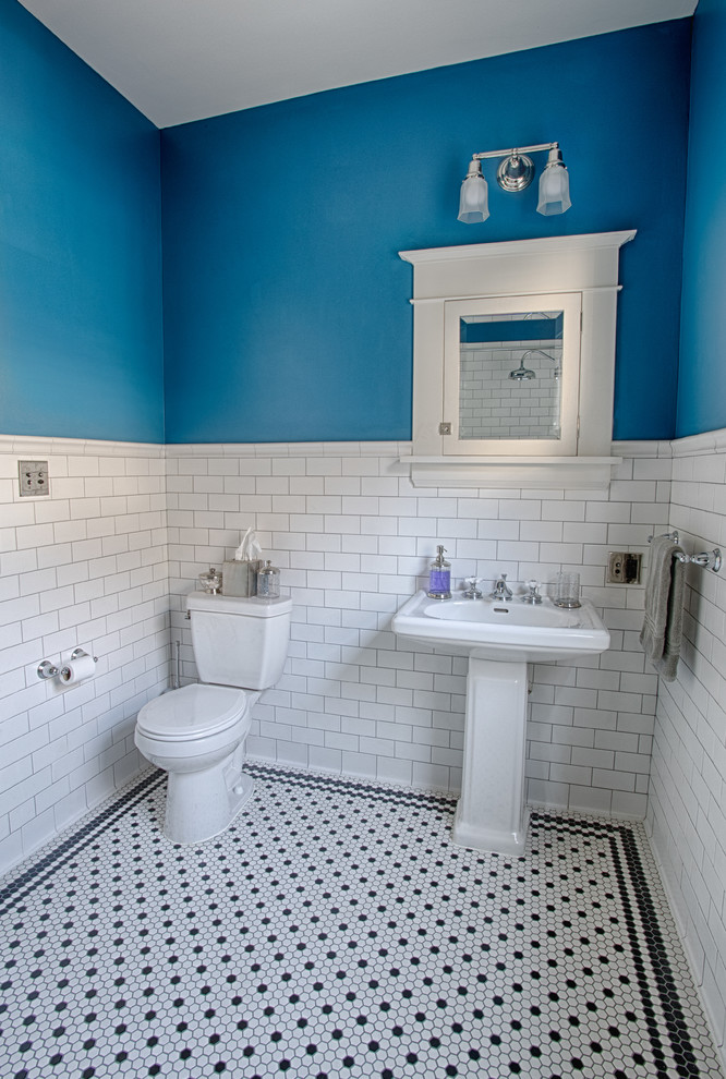 Inredning av ett klassiskt mellanstort badrum, med skåp i shakerstil, vita skåp, ett hörnbadkar, en dusch/badkar-kombination, en toalettstol med separat cisternkåpa, svart och vit kakel, keramikplattor, blå väggar, klinkergolv i keramik och ett piedestal handfat