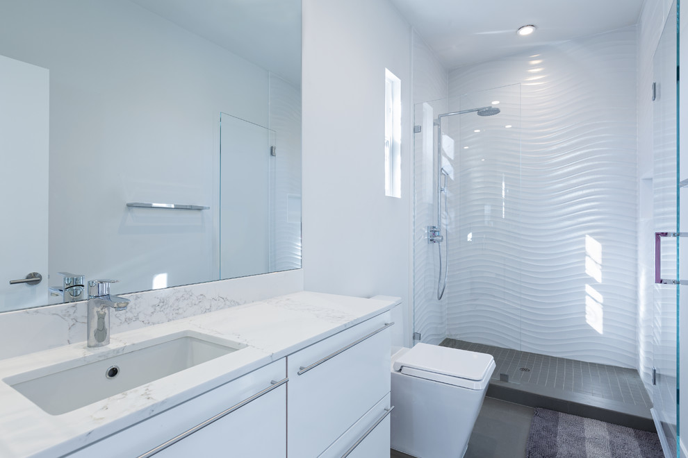 Doorless shower - small contemporary white tile and porcelain tile porcelain tile doorless shower idea in Orange County with flat-panel cabinets, white cabinets, a one-piece toilet, white walls, an undermount sink and quartz countertops