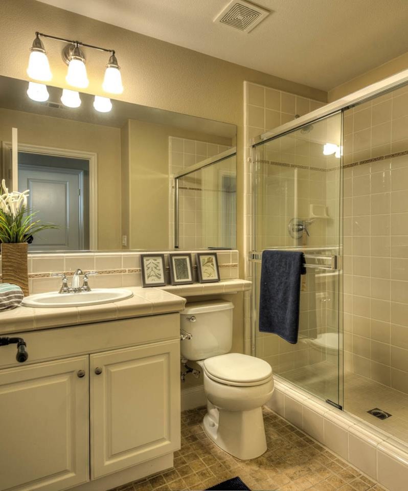 Example of a mid-sized transitional beige floor bathroom design in Orange County with raised-panel cabinets, white cabinets, beige walls and a drop-in sink
