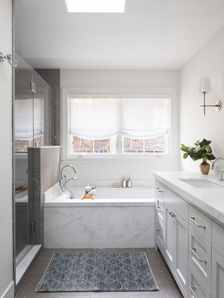 Пример оригинального дизайна: главная ванная комната среднего размера в стиле неоклассика (современная классика) с фасадами в стиле шейкер, серыми фасадами, полновстраиваемой ванной, душем в нише, унитазом-моноблоком, коричневой плиткой, мраморной плиткой, белыми стенами, мраморным полом, врезной раковиной, мраморной столешницей, коричневым полом, душем с распашными дверями и белой столешницей