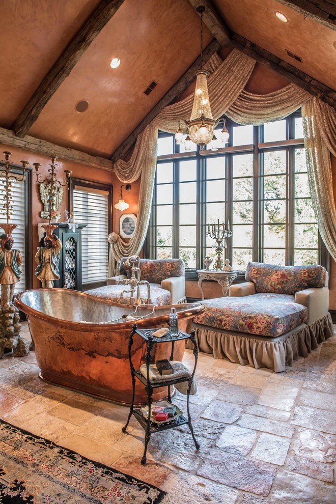 Foto de cuarto de baño principal romántico extra grande con bañera exenta, paredes marrones, suelo de piedra caliza y suelo marrón