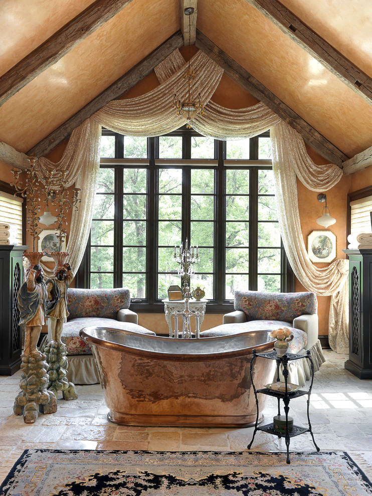 セントルイスにある広い地中海スタイルのおしゃれなマスターバスルーム (置き型浴槽、濃色木目調キャビネット、ベージュの壁、ライムストーンの床、ベージュの床) の写真