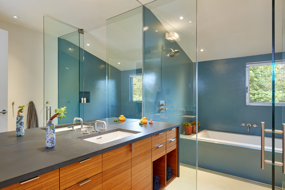 На фото: главная ванная комната в стиле модернизм с плоскими фасадами, фасадами цвета дерева среднего тона, накладной ванной, открытым душем, синей плиткой, синими стенами, врезной раковиной и столешницей из искусственного камня