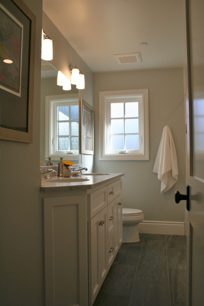 Idéer för att renovera ett mellanstort vintage badrum för barn, med skåp i shakerstil, vita skåp, ett badkar i en alkov, en dusch/badkar-kombination, en toalettstol med hel cisternkåpa, vit kakel, tunnelbanekakel, grå väggar, klinkergolv i porslin, ett undermonterad handfat, marmorbänkskiva, grått golv och dusch med duschdraperi