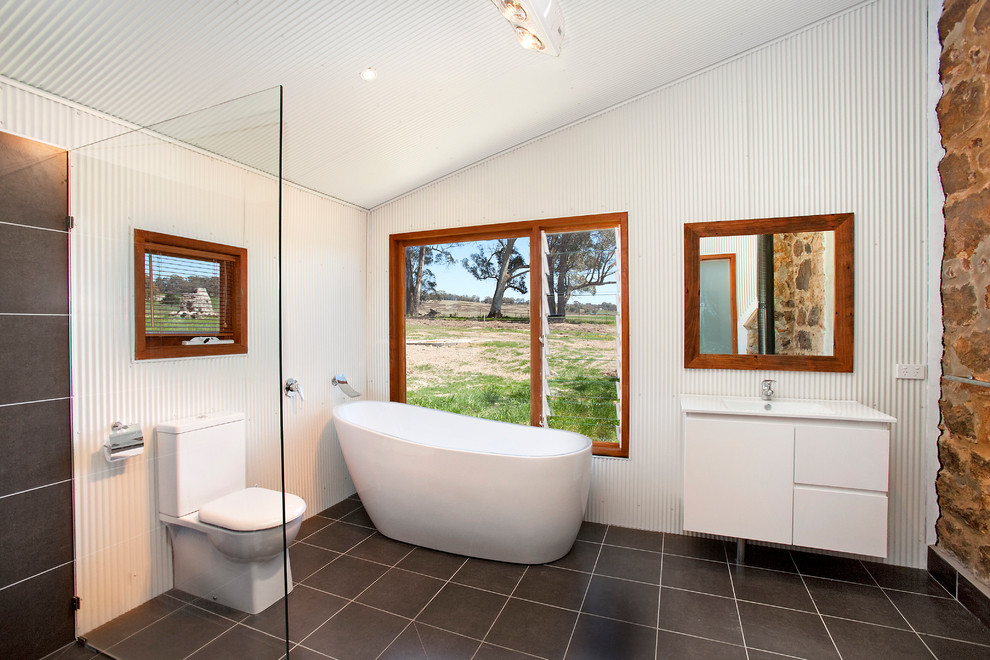 Industrial Badezimmer mit freistehender Badewanne, offener Dusche, offener Dusche und Steinwänden in Sydney