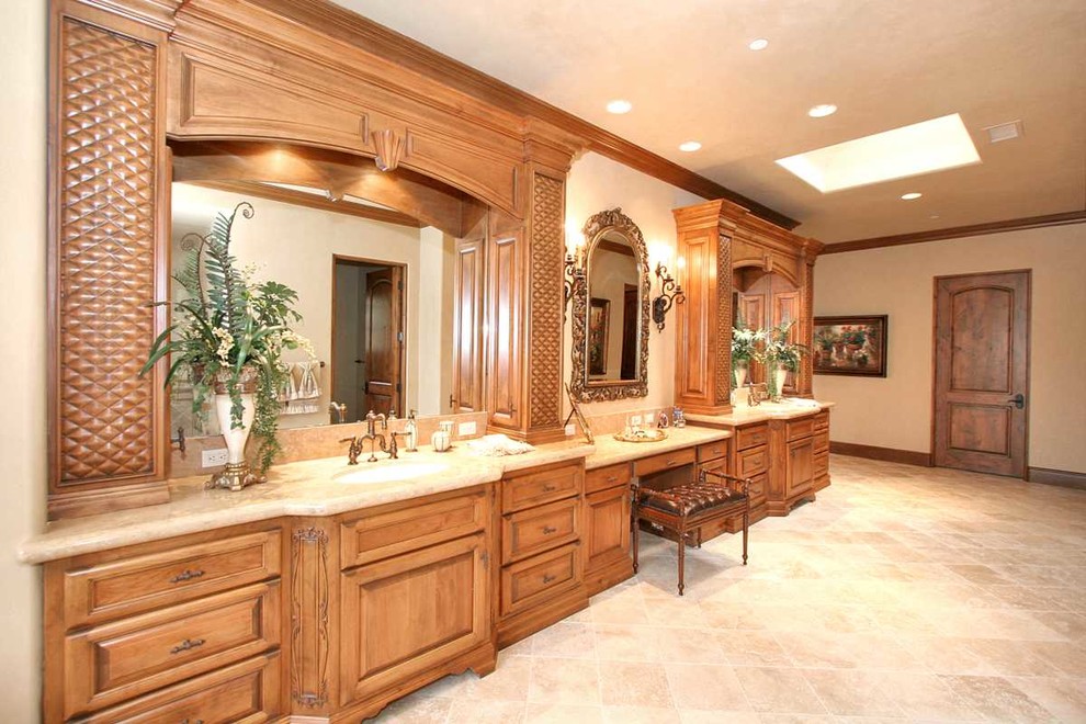 Inredning av ett medelhavsstil mycket stort en-suite badrum, med luckor med upphöjd panel, skåp i mellenmörkt trä, beige väggar, travertin golv, ett undermonterad handfat, bänkskiva i kalksten och beiget golv