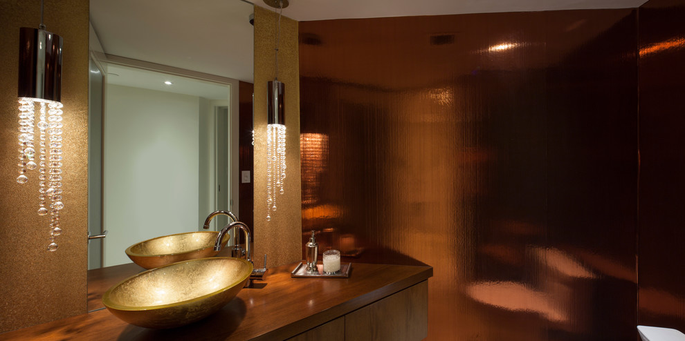 Foto di una stanza da bagno boho chic di medie dimensioni con ante lisce, ante in legno scuro, top in legno, WC monopezzo, lavabo a bacinella, pareti arancioni e pavimento in marmo