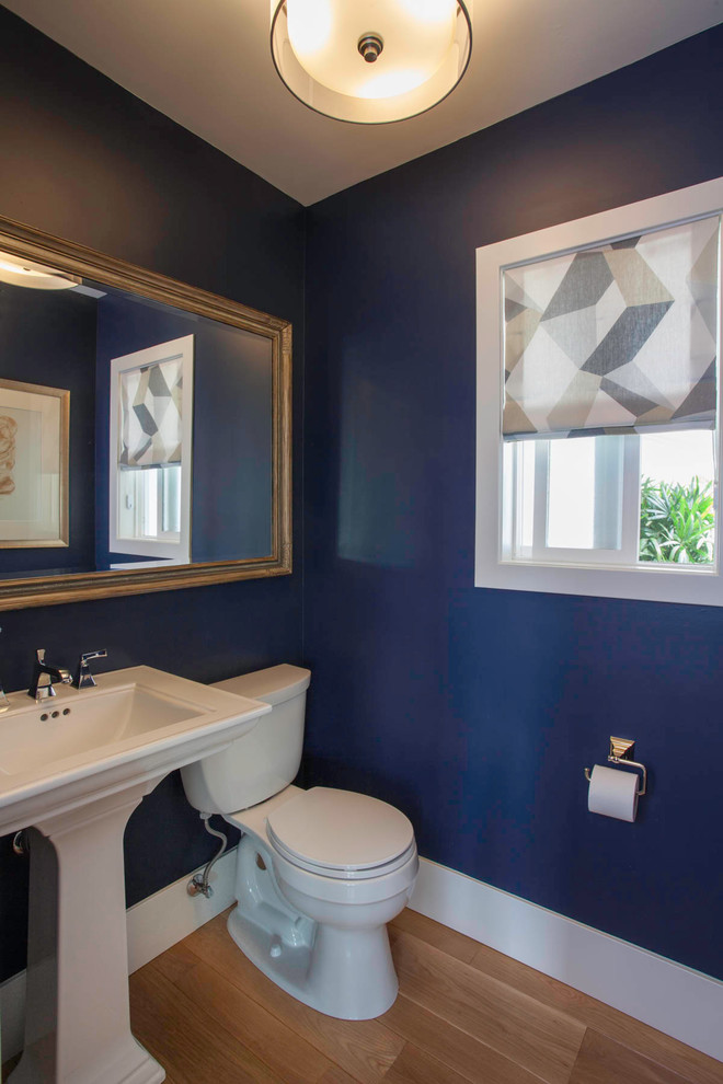 Ejemplo de cuarto de baño marinero pequeño con sanitario de dos piezas, paredes azules, suelo de madera en tonos medios, aseo y ducha, lavabo con pedestal y suelo beige