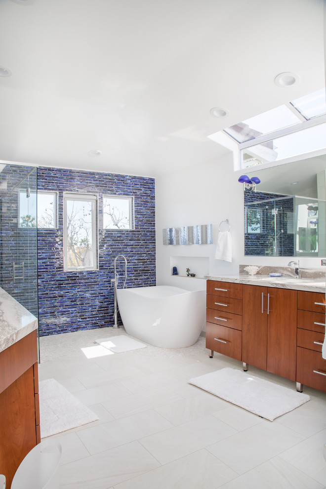 Inspiration for a mid-sized contemporary master blue tile and glass tile porcelain tile and white floor bathroom remodel in Orange County with flat-panel cabinets, medium tone wood cabinets, white walls, an undermount sink, a hinged shower door and beige countertops