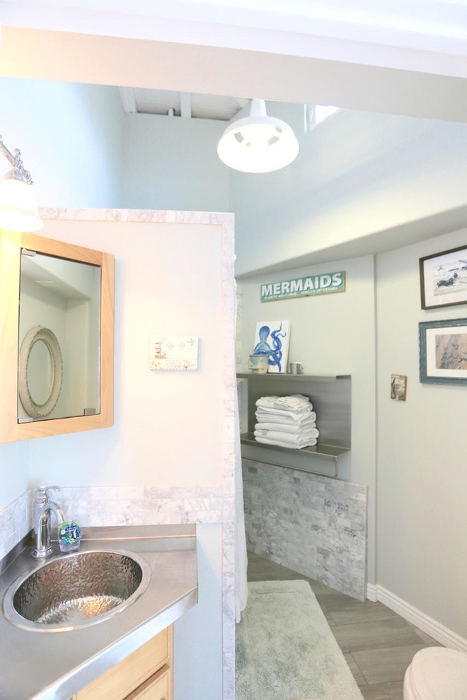 На фото: ванная комната среднего размера в морском стиле с светлыми деревянными фасадами, серой плиткой, белой плиткой, каменной плиткой, полом из керамогранита, накладной раковиной и столешницей из нержавеющей стали с
