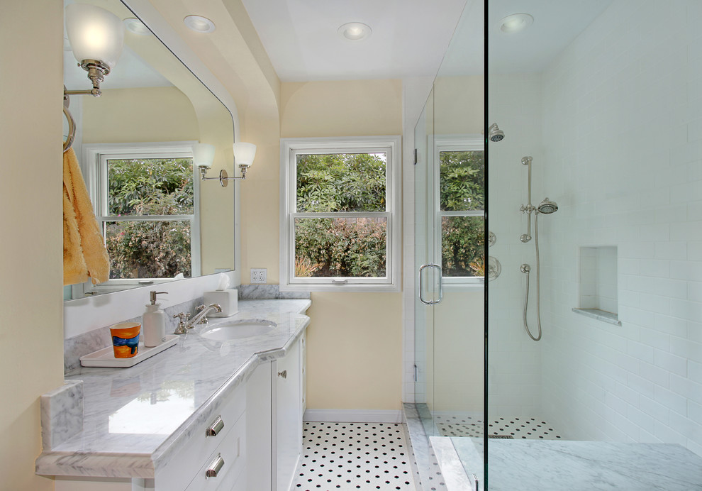 Bild på ett mellanstort amerikanskt badrum med dusch, med skåp i shakerstil, vita skåp, grå kakel, ett nedsänkt handfat, en dubbeldusch, gula väggar och mosaikgolv