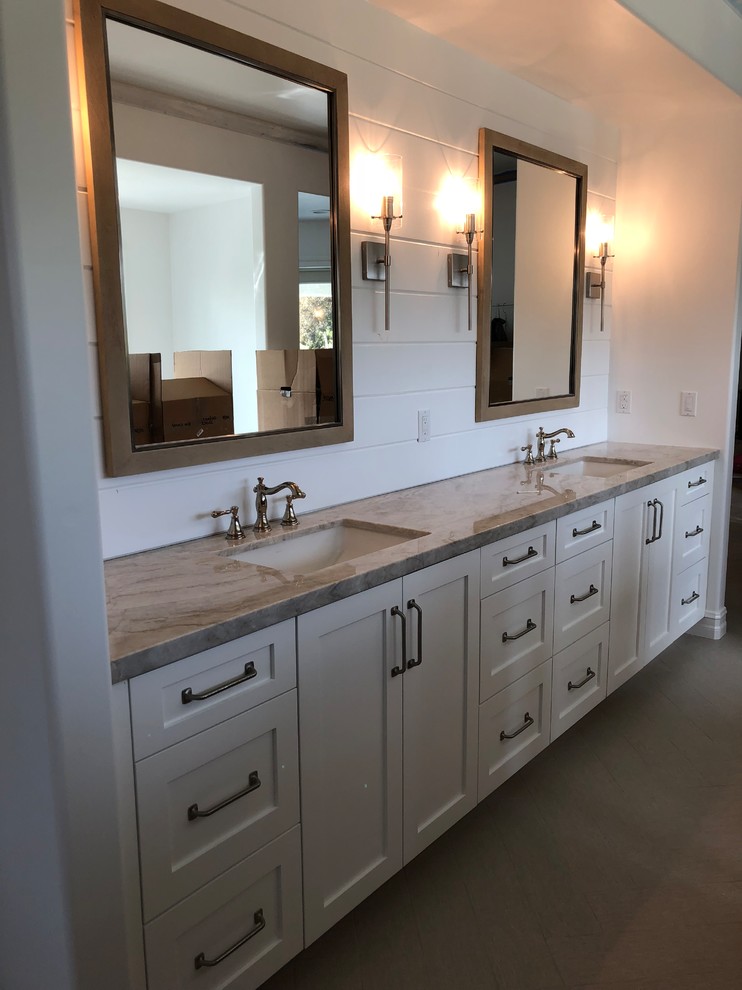 Bathroom - large country master brown floor bathroom idea in Orange County with shaker cabinets, white cabinets, white walls, an undermount sink, marble countertops and brown countertops