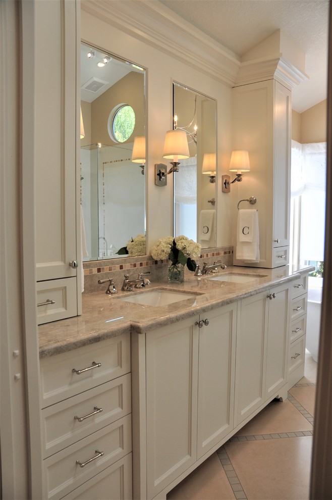 Medium sized classic ensuite bathroom in Orange County with white cabinets, a freestanding bath, a corner shower, a one-piece toilet, white tiles, porcelain tiles, beige walls, limestone flooring, a submerged sink, quartz worktops, beige floors, a hinged door, shaker cabinets, beige worktops, double sinks and a built in vanity unit.