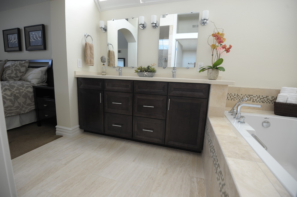 Inspiration for a mid-sized contemporary master beige tile and stone tile travertine floor drop-in bathtub remodel in Orange County with an undermount sink, shaker cabinets, dark wood cabinets, quartz countertops and a one-piece toilet