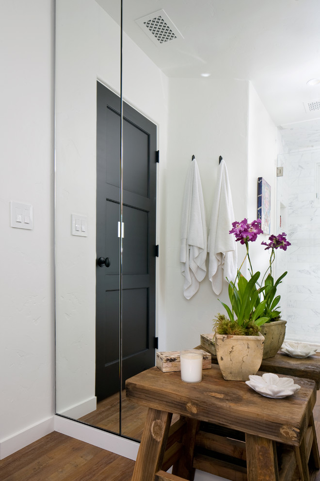Exempel på ett mellanstort medelhavsstil en-suite badrum, med ett väggmonterat handfat, ett badkar i en alkov, en dusch/badkar-kombination, en toalettstol med hel cisternkåpa, vit kakel, keramikplattor, vita väggar och mellanmörkt trägolv