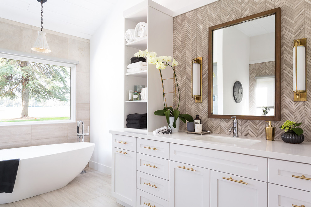 Свежая идея для дизайна: главная ванная комната в стиле неоклассика (современная классика) с фасадами в стиле шейкер, бежевыми фасадами, отдельно стоящей ванной, бежевой плиткой, врезной раковиной и зеркалом с подсветкой - отличное фото интерьера