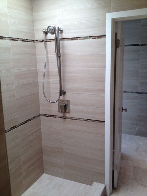 This is an example of a medium sized contemporary ensuite bathroom in Orange County with a submerged sink, flat-panel cabinets, dark wood cabinets, granite worktops, an alcove shower, beige tiles, porcelain tiles, beige walls and travertine flooring.