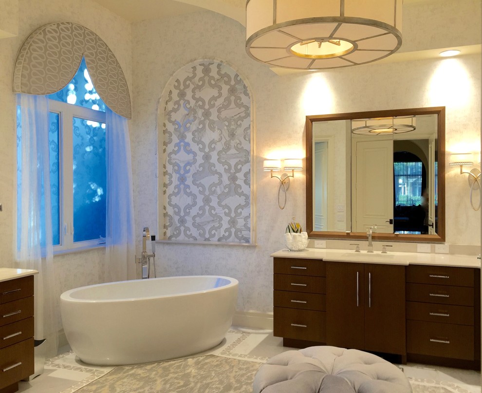 Cette image montre une grande douche en alcôve principale traditionnelle en bois brun avec un placard à porte plane, une baignoire indépendante, un carrelage blanc, un carrelage de pierre, un mur gris, un sol en marbre, un lavabo encastré et un plan de toilette en quartz.