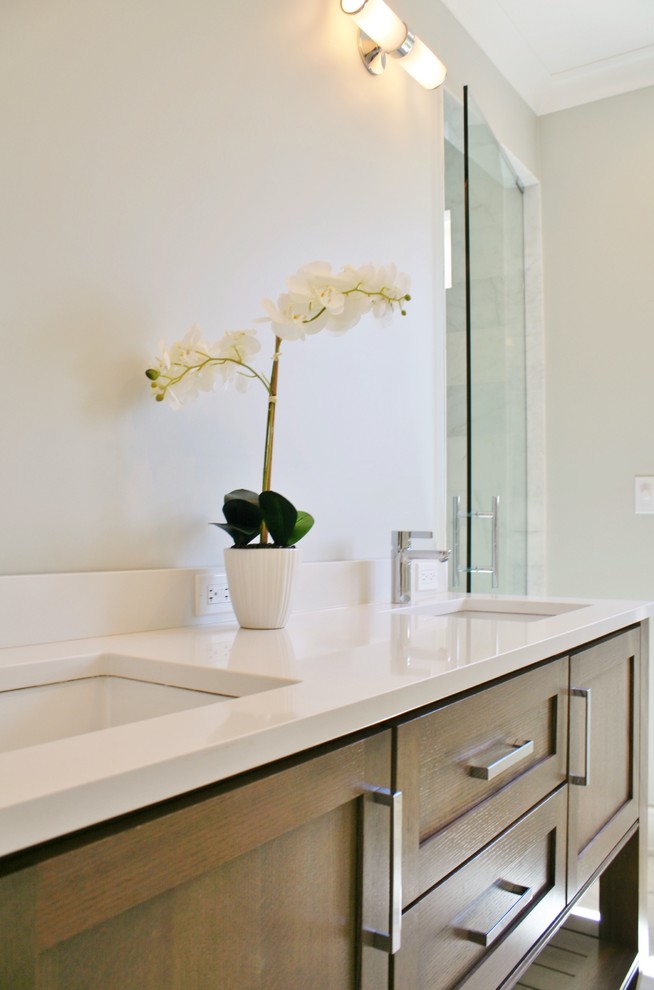 Aménagement d'une salle de bain principale classique en bois brun de taille moyenne avec un placard à porte shaker, une baignoire indépendante, un mur gris, un lavabo encastré et un plan de toilette en quartz modifié.