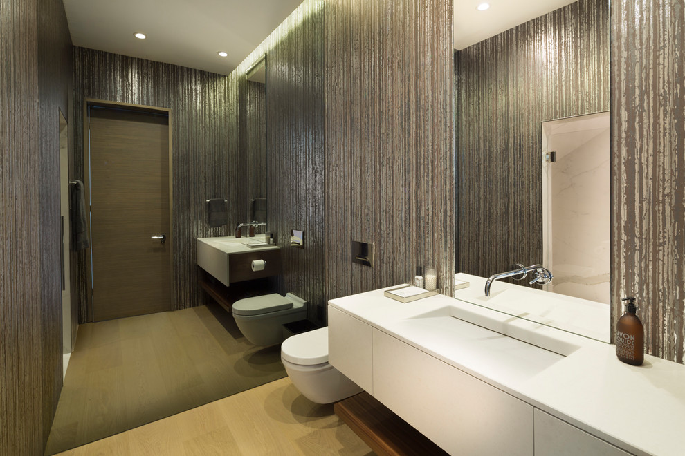 Modernes Duschbad mit flächenbündigen Schrankfronten, weißen Schränken, hellem Holzboden, Wandtoilette, brauner Wandfarbe, integriertem Waschbecken und beigem Boden in Austin