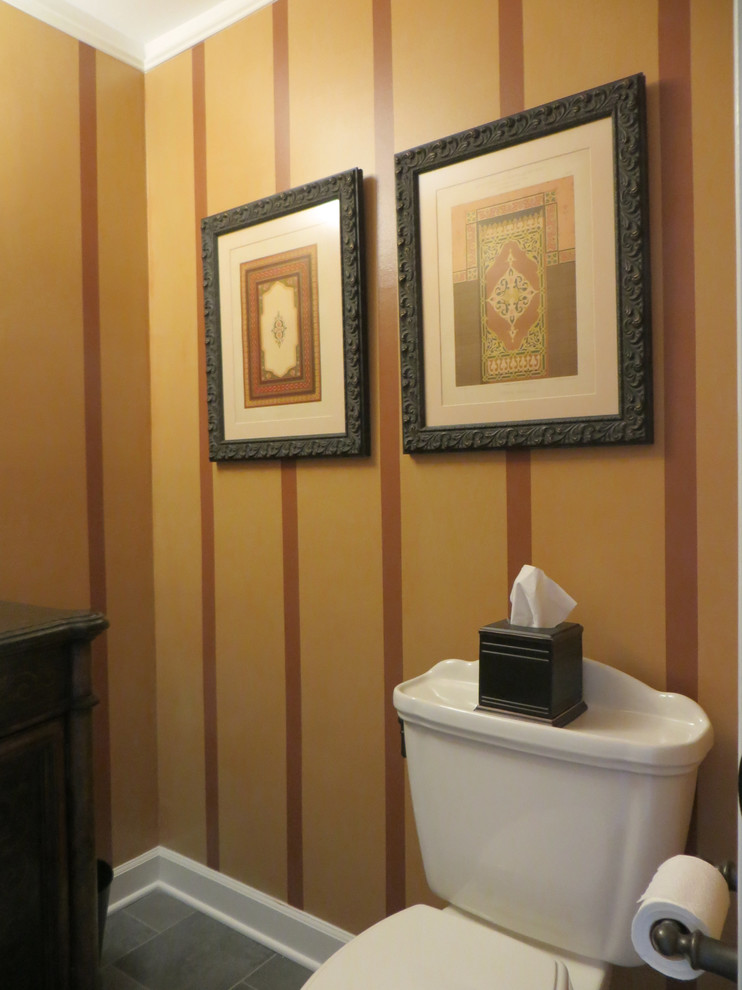Kleine Klassische Gästetoilette mit Einbauwaschbecken, Kassettenfronten, dunklen Holzschränken, oranger Wandfarbe und Porzellan-Bodenfliesen in Chicago