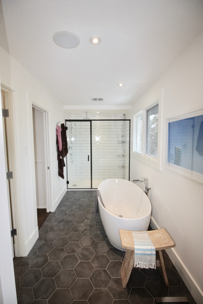 Idéer för att renovera ett mellanstort funkis vit vitt en-suite badrum, med släta luckor, skåp i ljust trä, ett fristående badkar, en dusch i en alkov, tunnelbanekakel, vita väggar, cementgolv, ett fristående handfat, bänkskiva i akrylsten, grått golv och dusch med gångjärnsdörr