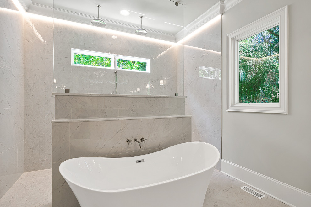 Foto på ett stort vintage vit en-suite badrum, med luckor med infälld panel, vita skåp, ett fristående badkar, en kantlös dusch, vit kakel, marmorkakel, blå väggar, mellanmörkt trägolv, ett undermonterad handfat, marmorbänkskiva, vitt golv och med dusch som är öppen