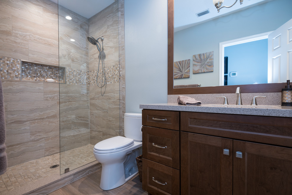 Photo of a medium sized classic shower room bathroom in Orlando with shaker cabinets, dark wood cabinets, an alcove shower, a two-piece toilet, beige tiles, porcelain tiles, grey walls, medium hardwood flooring, a submerged sink, blue floors and an open shower.
