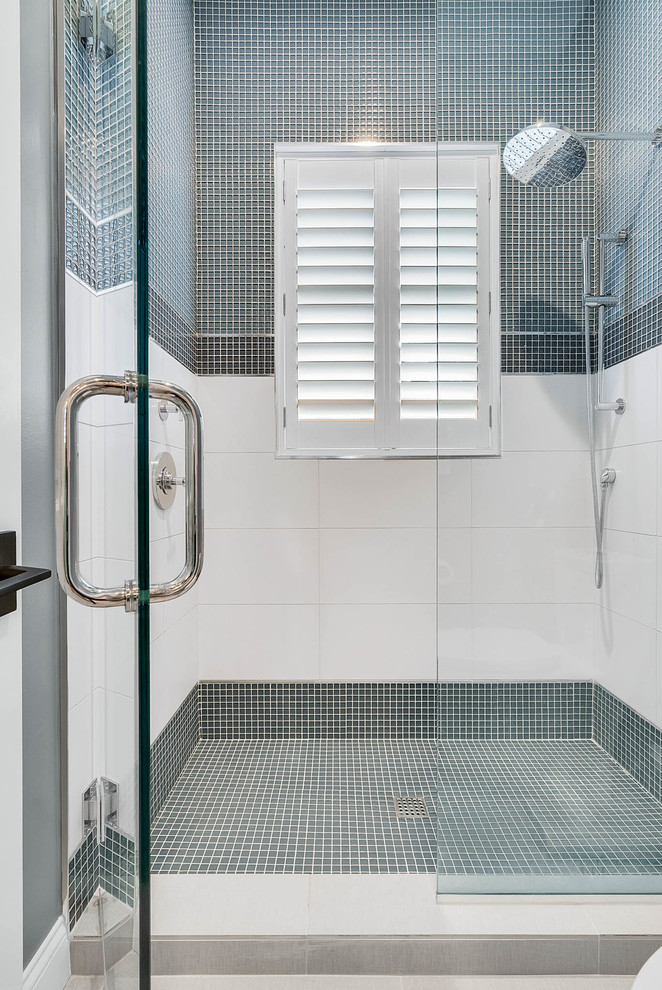 Свежая идея для дизайна: большая главная ванная комната в стиле неоклассика (современная классика) с плоскими фасадами, темными деревянными фасадами, душем в нише, синей плиткой, плиткой мозаикой, серыми стенами, полом из ламината, настольной раковиной, столешницей из известняка, серым полом и душем с распашными дверями - отличное фото интерьера