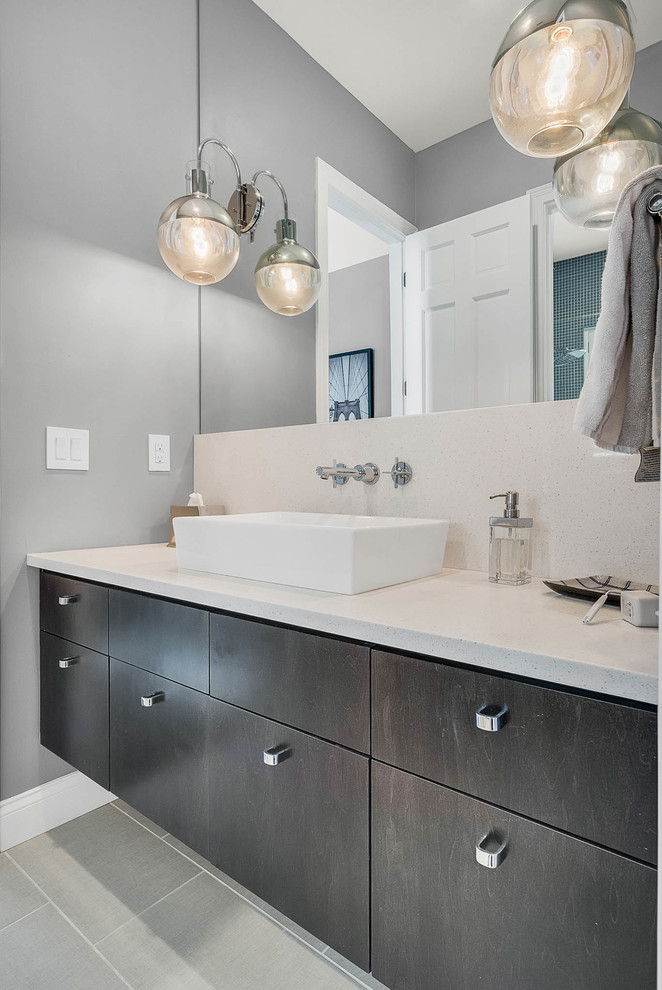 Inspiration for a large transitional master blue tile and mosaic tile laminate floor and gray floor alcove shower remodel in Orlando with flat-panel cabinets, dark wood cabinets, gray walls, a vessel sink, limestone countertops and a hinged shower door