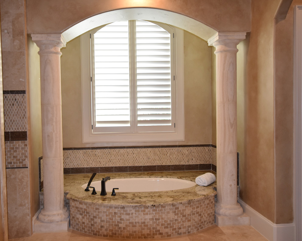 Inspiration for a huge mediterranean master beige tile and stone tile travertine floor alcove shower remodel in Houston with raised-panel cabinets, dark wood cabinets, an undermount tub, a two-piece toilet, an undermount sink and granite countertops
