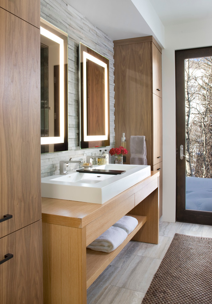 Réalisation d'une salle de bain design en bois clair avec un lavabo posé, un placard à porte plane, un plan de toilette en bois et un mur blanc.