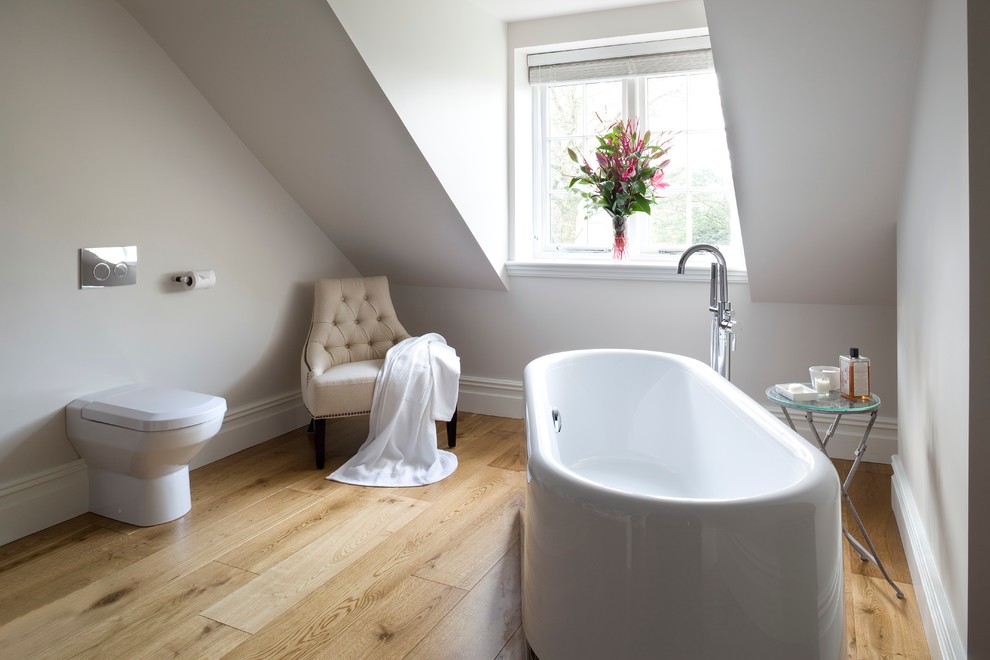 На фото: главная ванная комната в современном стиле с отдельно стоящей ванной, белыми стенами и унитазом-моноблоком с