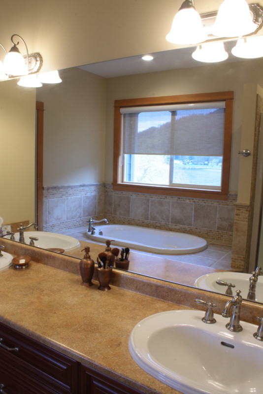 Foto de cuarto de baño principal tradicional con armarios con paneles con relieve, puertas de armario de madera en tonos medios, bañera encastrada, ducha empotrada, baldosas y/o azulejos beige, paredes beige y lavabo encastrado