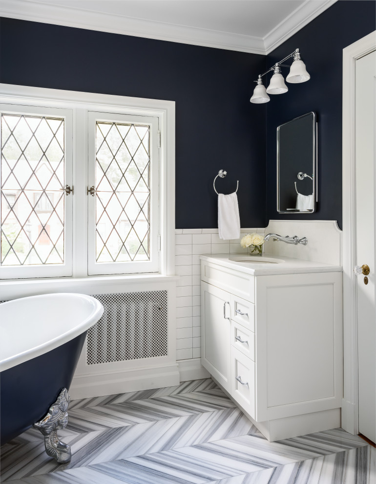 Medium sized classic family bathroom in St Louis with recessed-panel cabinets, white cabinets, a claw-foot bath, a corner shower, a one-piece toilet, white tiles, ceramic tiles, blue walls, marble flooring, a submerged sink, engineered stone worktops, grey floors, a hinged door and white worktops.