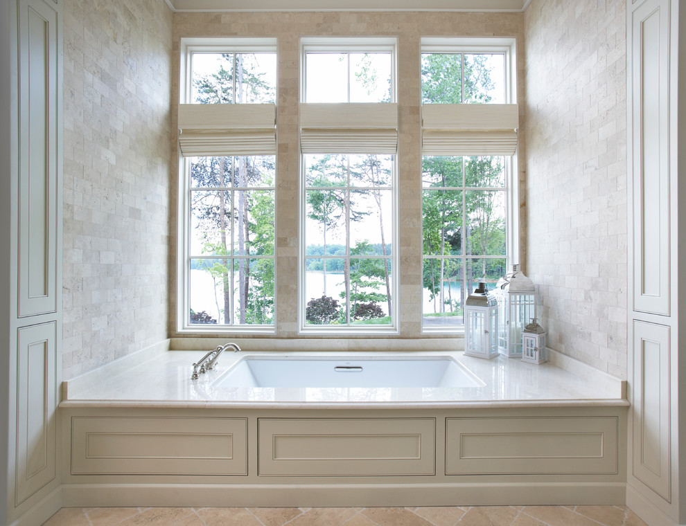 Idéer för ett mycket stort klassiskt en-suite badrum, med ett undermonterad handfat, släta luckor, grå skåp, marmorbänkskiva, ett undermonterat badkar, beige kakel, grå väggar, travertin golv och travertinkakel