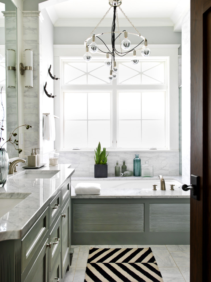 Foto de cuarto de baño principal y gris y blanco tradicional renovado con lavabo bajoencimera, armarios con paneles empotrados, puertas de armario grises, bañera encastrada sin remate, baldosas y/o azulejos blancos, paredes grises y ventanas