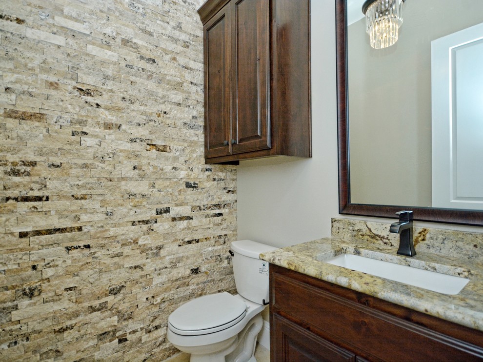 Example of a mid-sized mountain style master beige tile and stone tile travertine floor bathroom design in Austin with raised-panel cabinets, medium tone wood cabinets, beige walls, an undermount sink, granite countertops and a two-piece toilet