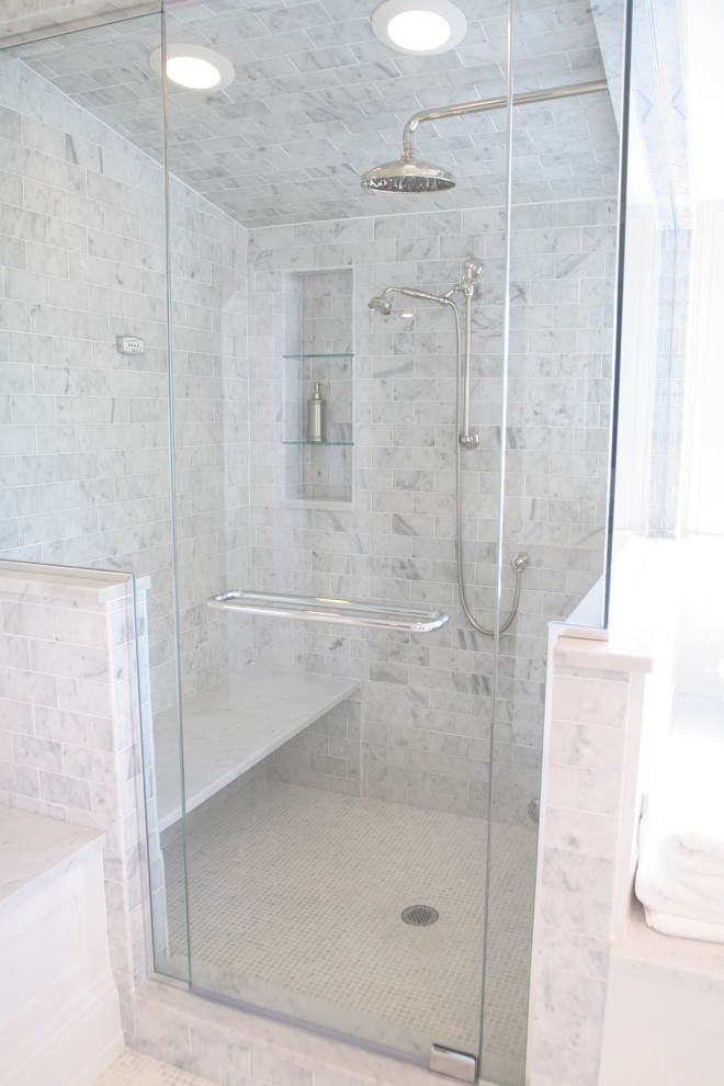 Cette photo montre une salle de bain chic de taille moyenne avec un lavabo encastré, un placard à porte shaker, des portes de placard blanches, un plan de toilette en marbre, une baignoire posée, WC séparés, un carrelage blanc, mosaïque, un mur beige et un sol en marbre.