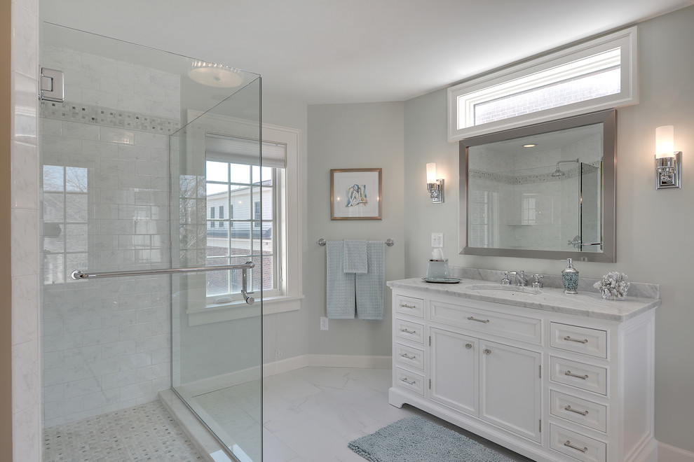 Exempel på ett stort klassiskt en-suite badrum, med ett undermonterad handfat, möbel-liknande, vita skåp, marmorbänkskiva, ett fristående badkar, en hörndusch, vit kakel, porslinskakel, klinkergolv i porslin och grå väggar