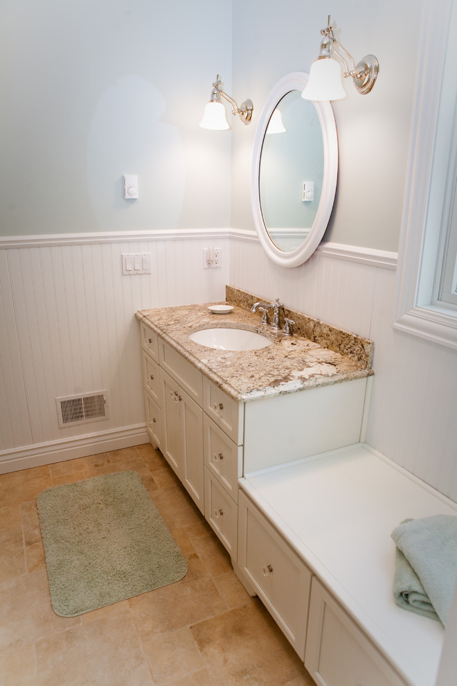 Example of a large classic brown tile and stone tile limestone floor alcove shower design in Grand Rapids with an undermount sink, shaker cabinets, white cabinets, granite countertops, a two-piece toilet and blue walls