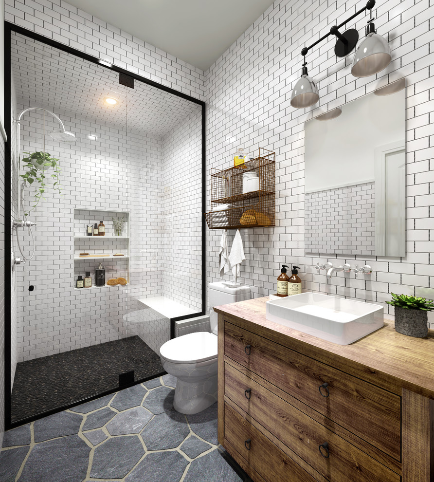 Exemple d'une salle de bain tendance en bois brun de taille moyenne avec un placard en trompe-l'oeil, WC à poser, un carrelage blanc, un carrelage métro, un mur blanc, une vasque, un plan de toilette en bois, un sol gris, une cabine de douche à porte battante et un plan de toilette marron.